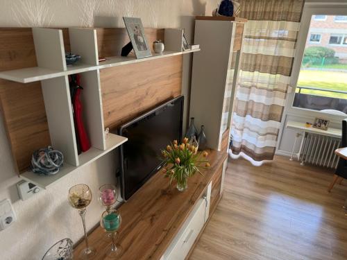 a living room with a television and a table with wine glasses at Apartment Rita in Hannover