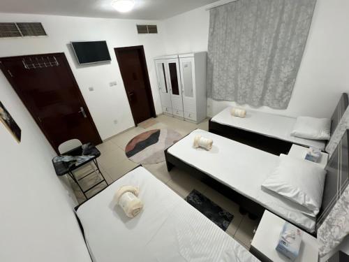 a small room with two beds and a window at ALEX Hostel C2602 - Bed in Shared Room for Males in Sharjah