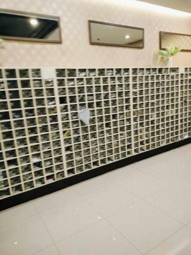 a bathroom with a black and white tile wall at JY7 Rooms 414 in Cebu City