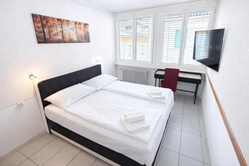 a small bedroom with a bed and a desk at Hotel San Carlo in Lugano