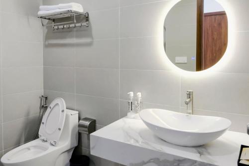 a bathroom with a sink and a toilet and a mirror at KHEM BEACH Hotel in Phú Quốc