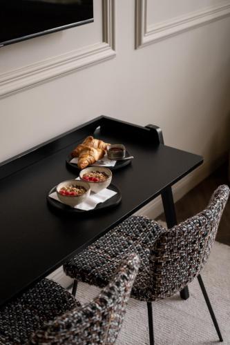 a black table with two bowls of food and two chairs at Steenhof Residence Warmond in Warmond