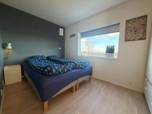 a bedroom with a bed and a window at Sea View apartment in Askøy