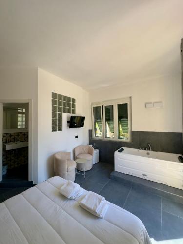 a white bedroom with a bed and a bath tub at Da Zoe suite fontanavecchia in Vernazza