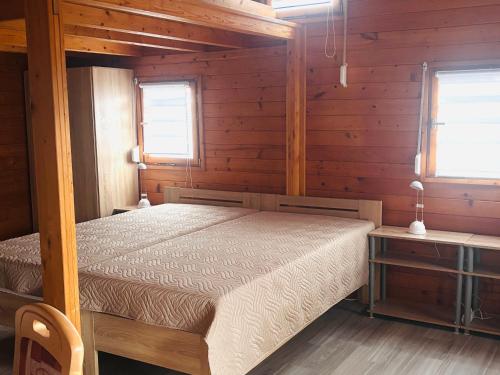 a bedroom with a bed in a wooden cabin at Seeperle am Concordia See in Friedrichsaue