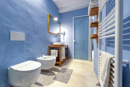 a blue bathroom with a toilet and a sink at Corte Piri in Tricase