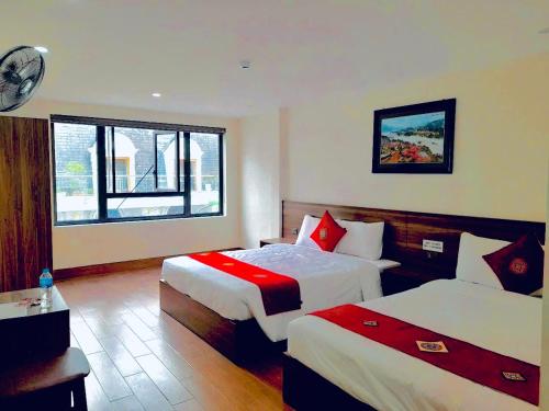a hotel room with two beds and a window at OnMe in Sapa