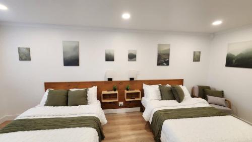 two beds in a room with paintings on the wall at #4 Hygge Hus Hotel - Double Room Suite Connectable in Andrews
