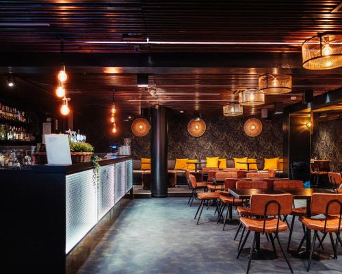 a restaurant with tables and chairs and a bar at Hotel Emilia in Hämeenlinna