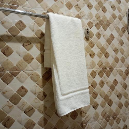 a white towel hanging on a towel rack in a bathroom at الاطلاله للشقق المخدومة in Khamis Mushayt