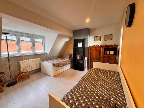 a bedroom with a bed and a couch and windows at La cachette du Beffroi - Appt 30 m² centre Arras in Arras