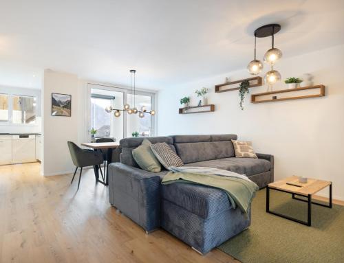a living room with a couch and a table at Spacious & Modern Apt - Balcony & Parking in Spiez