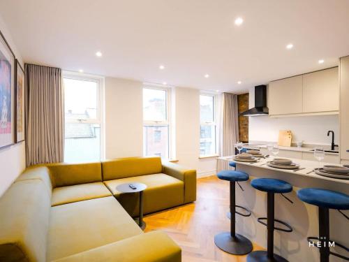 a living room with a couch and a kitchen at Herringbone at The Heim in Manchester