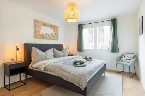 a bedroom with a bed with a teddy bear on it at Spacious & Modern Apt - Balcony & Parking in Spiez