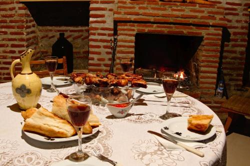 een tafel met een bord eten en een glas wijn bij Guest House Aisi in Sighnaghi