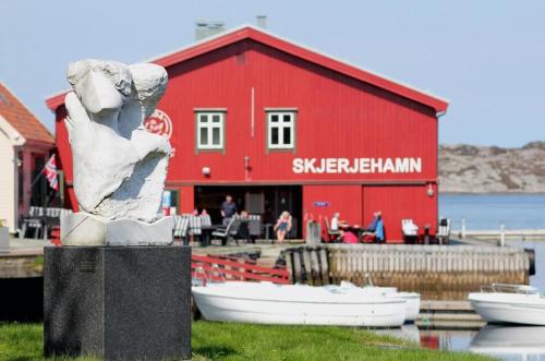 Skjerjehamn في Ånneland: تمثال أمام مبنى أحمر