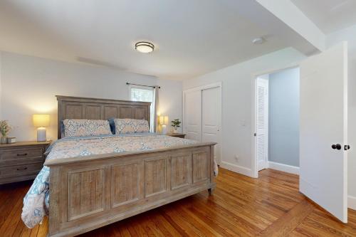 a bedroom with a large wooden bed and wooden floors at Game Day Hub < 1 Mi to Stadium & Patriot Place! in Foxborough