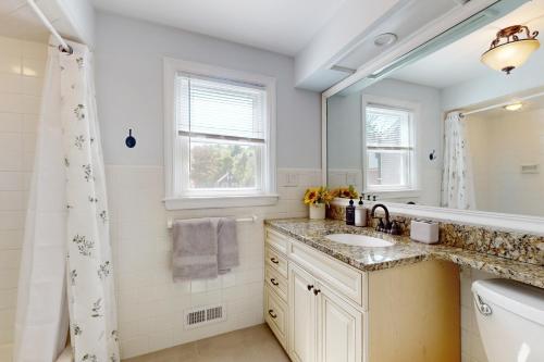 a bathroom with a sink and a mirror at Game Day Hub < 1 Mi to Stadium & Patriot Place! in Foxborough