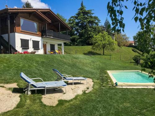 a house with a swimming pool and two lounge chairs at Villa Tirolese in Due Cossani