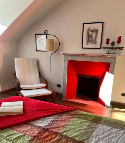 a room with a red fireplace and a chair at Relax Luino vista lago Casa LEA in Luino