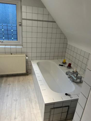 a white bathroom with a tub and a window at Silk and Stone Manor in Grez-Doiceau
