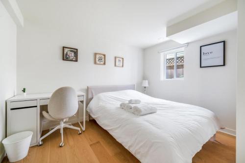 a bedroom with a bed and a desk and a chair at Picturesque room surrounded by flowers with share spaces in Vancouver