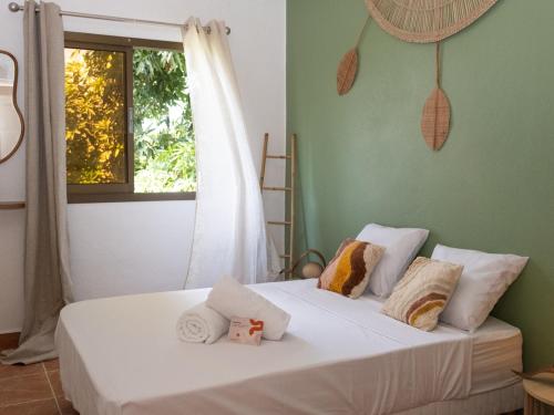 a bedroom with a white bed with pillows and a window at T4 Oasis tropicale x Nawassi in Pamandzi
