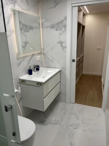 a white bathroom with a sink and a toilet at Lorenzo in Benaguacil