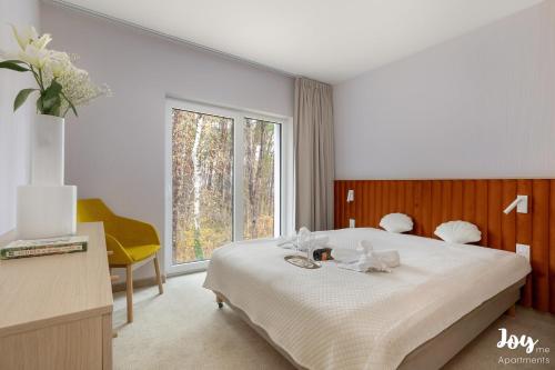 a bedroom with a bed and a large window at Apartamenty Łukęcin Joy me 3 in Łukęcin