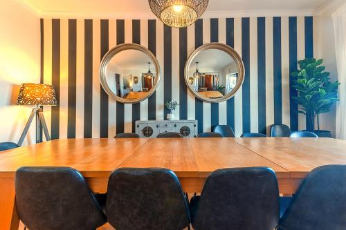 a conference room with a table and chairs and mirrors at Apolónia 3E Five Bedrooms in Lisbon