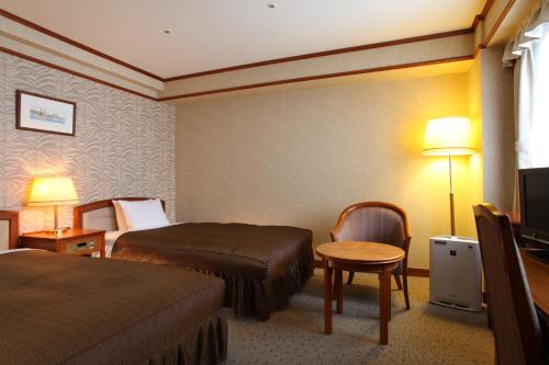 神戸市にあるホテルヴィアマーレ神戸のベッド2台とテレビが備わるホテルルームです。