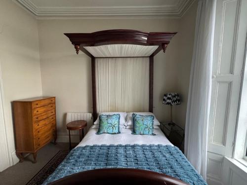 a bedroom with a bed with a wooden headboard and pillows at Anns Sea View Suite in Cobh