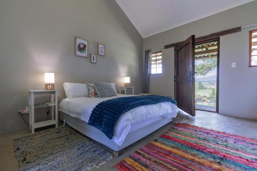 ein Schlafzimmer mit einem Bett und einem bunten Teppich in der Unterkunft Falling Waters in Nottingham Road