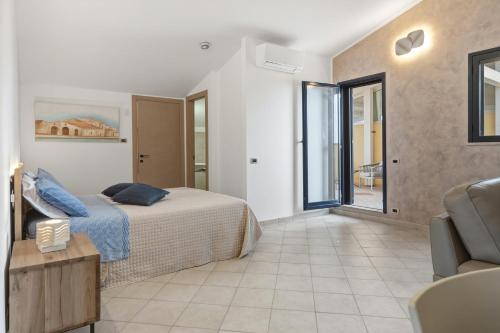 a bedroom with a bed and a chair at Case Vacanze Celeste in Marzamemi