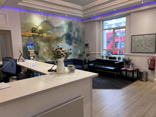 a living room with a couch and a table with flowers at Lidos Hotel in London