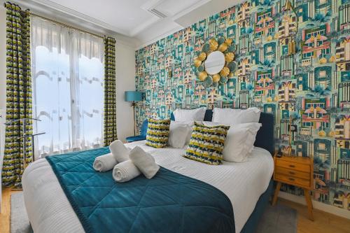 a bedroom with a large bed with a colorful wallpaper at La Maison Kléber - Luxury apartments, Eiffel Tower - Champs-Elysées in Paris