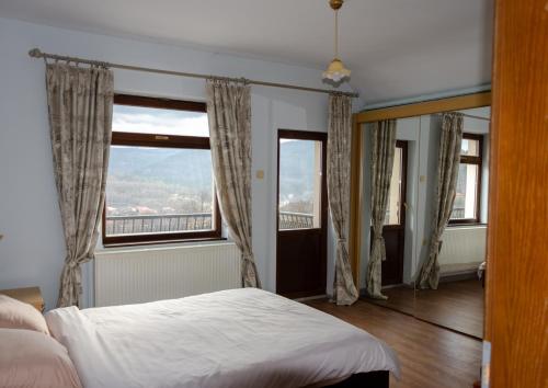 a bedroom with a bed and two windows at Villa “Nadezhda” in Tsareva Livada