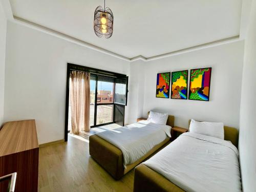 a room with two beds and a window at Atlantic View Duplex Tawenza Bay in Taghazout