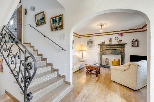 a living room with a staircase and a fireplace at Casa Naima: Family House | Terrace & Peaceful Location - Happy Rentals in Breno