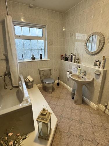 a bathroom with a toilet and a sink and a tub at Dernvale House -Double Room sleeps 2 in Mullinderg