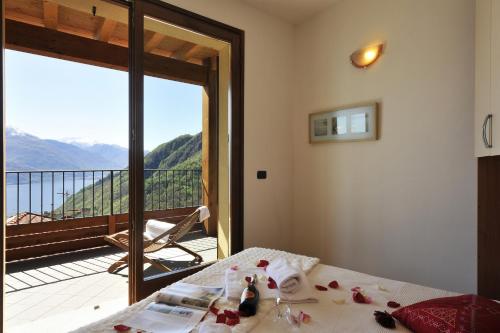 a bedroom with a bed with a view of a balcony at Borgo La Sorgente - Erica in Gravedona