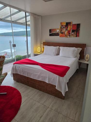 a bedroom with a large bed with a large window at Hotel Boutique Coração Aberto in Capitólio