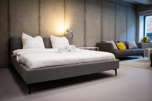 a large bed in a room with a couch at Spreeblick Studio Design-Loft mit Terrasse & Parkplatz in Berlin