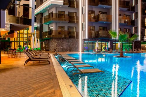 a swimming pool with lounge chairs in a building at SA Apartments! Cleopatra Beach Duplex with Terrace in Alanya