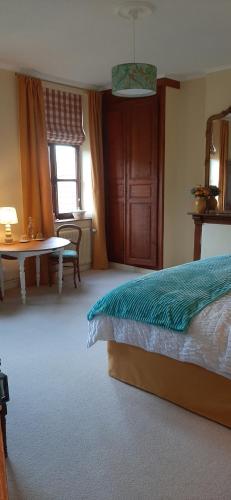 a bedroom with a bed and a table and a window at Les Tourelles in Contes