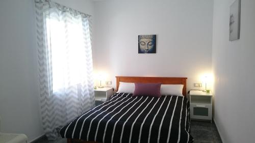 um quarto com uma cama com um cobertor listrado preto e branco em Apartment Periañez em Alicante