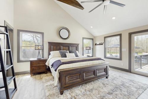 a bedroom with a large bed and windows at Outdoor Wonderland! Home 12 Mi to Lake George in Fort Ann