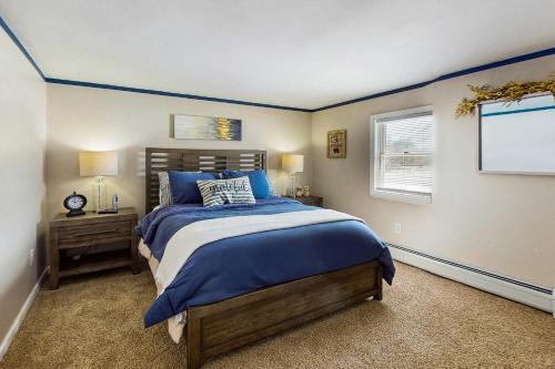a bedroom with a bed with blue sheets and a window at 12 Mi to Lake George! Quiet Adirondack Escape in Fort Ann