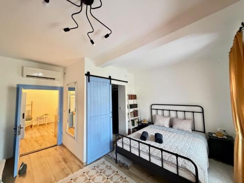 a bedroom with a bed and a ceiling with a chandelier at Kökény Kunyhó in Kisszékely