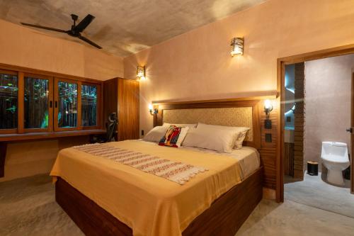 a bedroom with a large bed and a bathroom at Casa Maradi-Arena in Mazunte
